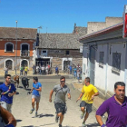 Varios jóvenes corren delante de los novillos en el último encierro.-E. M.