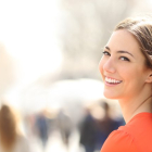 Chica joven sonriendo en la calle.-123RF