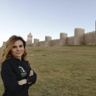 Gemma Rodríguez, ataviada con un delantal de Ávila Auténtica, delante de la imponente muralla romana abulense.-