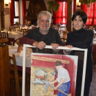 Luis Fernando y Laura con un cuadro en el que aparece Justo Berzal fundador del asador en medio del comedor del restaurante.-ARGICOMUNICACIÓN