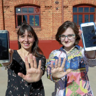 Susana Núñez e Iris Elena Muñoz muestran sus móviles en los alrededores de la Facultad de Comercio de Valladolid.-J. M. LOSTAU