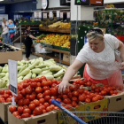 Una mujer compra tomates en un supermercado de Moscú.-YURI KOCHETKOV