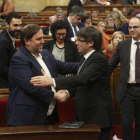 Junqueras y Puigdemont se saludan en el Parlament, en marzo.-DANNY CAMINAL