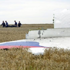 Varias personas transportan un cadáver en una camilla en medio de los destrozos de un Boeing 777, vuelo MH17 de Malaysia Airlines, derribado cerca de Donetsk (Ucrania).-EFE / ANASTASIA VLASOVA