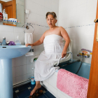 Juana Macay, en el baño de su casa, con los aparatos adaptados para el aseo. / J.M. LOSTAU