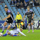 Álex Pérez intenta llevarse el balón ante la presencia de Juanmi, ayer en Anoeta.-ARABA PRESS