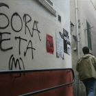 Una persona junto a un graffiti proetarra.-VINCENT WEST