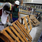 Unos manifestantes levantan una barricada en Caracas.-REUTERS / CARLOS GARCIA RAWLINS