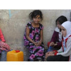 Niñas yemenís esperan para coger agua en una fuente potable en Saná.-EFE
