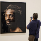 Una hombre fotografía un retrato de Pierre Gonnord.-C.A.