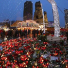 Altar de flores y velas en el mercadillo navideño de Berlín, que ayer reabrió.-AP / MARCUS SCHREIBER