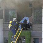 Un bombero rompe el cristal de la entreplanta del bar para poder soficar el incendio.-Pablo Requejo