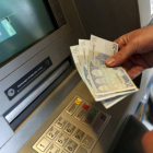 Un hombre retira 60 euros de un cajero en Atenas, Grecia.-Foto: REUTERS / YANNIS BEHRAKIS