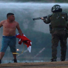 Un polícia en Chile apunta con su arma a un manifestante.-REUTERS