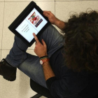 Una lectora, consultando un libro de recetas en una tablet.-ELISENDA PONS