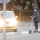 Un joven con un patinete cruza un paso de peatones en una calle de Valladolid. J.M. LOSTAU