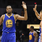 Kevin Durant choca con Stephen Curry durante un partido de pretemporada contra los Lakers.-AP / DENIS POROY