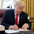 Trump firma la ley sobre la reforma fiscal, en el Despacho Oval de la Casa Blanca, en Washington, el 22 de diciembre.-/ EFE / MICHAEL REYNOLDS