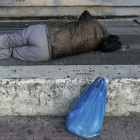 Una persona 'sintecho' duerme en la calle.-AP