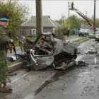 Un soldado permanece junto a un vehiculo calcinado en el lugar del ataque.-RPD / ALEXANDER ERMOCHENKO