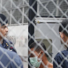 Agentes de policia tailandeses custodian la llegada de un sospechoso de trata de personas en el tribunal penal de Bangkok este miércoles-NARONG SANGNAK