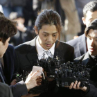 El cantante Jung Joon-young, en el centro, al llegar a la comisaría central de Seúl, el pasado marzo.-AP / AHN YOUNG-JOON