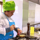 Una estudiante de cocina trabaja en la elaboración de un plato en los fogones de una escuela.-ICAL
