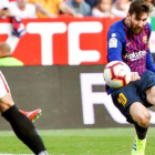 Messi dispara a la portería del Sevilla.-RAÚL CARO (EFE)