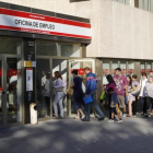 Cola de parados ante una oficina de empleo.-