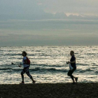 Miembros de Barcelona Plogging, al amanecer en la Barceloneta. Antes de correr, te dan una bolsa biodegradable y un par de guantes. La próxima quedada es el 7 de noviembre.-JOAN CORTADELLAS