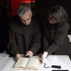 El Padre Juan Dobado, comisario de la exposición 'Teresa de Jesús, La prueba de mi verdad' y la restauradora, Charo Fernández, examinan la segunda redacción del manuscrito autógrafo de La Santa 'Camino de perfección'-Ical