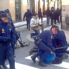 Agentes de antidisturbios reducen a dos manifestantes ante el restaurante de La Parrilla de San Lorenzo.-L. B. ÁLBER