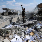 Un soldado sirio filma los escombros tras un ataque de las fuerzas estadounidenses, francesas y británicas el 14 de abril del 2018 para castigar al presidente Bashar el Asad por el uso de armas químicas contra civiles.-/ HASSAN AMMAR (AP)