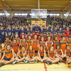 Participantes del colegio San Agustín en la Copa Colegial posan con el ex jugador norteamericano Joe Arlauckas con una grada del pabellón completa.-MIGUEL ÁNGEL SANTOS