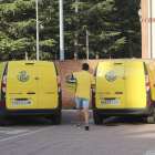 Un repartidor de Correos, en Palencia, se dispone a cargar una caja con cartas en un vehículo