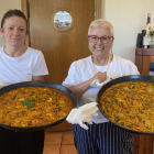 Eva Munera y Laura Fernández con dos paellas antes de servir a la mesa en el restaurante Villa Mencía en Corullón. /