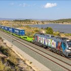 Tren de mercancías con varios semirremolques a bordo en una autopista ferroviaria.