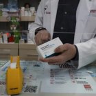 Un farmacéutico con una caja de paracetamol en su farmacia