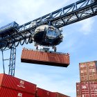 Una grúa coloca un contenedor destinado a la exportación en la terminal de carga de un puerto internacional en una foto de archivo.