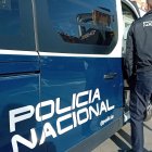 Un agente de la Policía Nacional delante de un furgón.