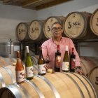 Benjamín García posa con sus vinos en la sala de barricas de Bodegas La Mela.