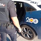 Imagen de archivo de un agente de la Policía Nacional junto a un vehículo policial.