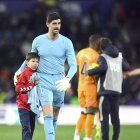 Courtois junto a un recogepelotas.