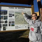 Inma Gómez señala el panel informativo de las rutas de senderismo habilitadas en Torre de Esgueva.
