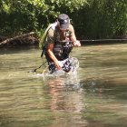 Un aficionado con una trucha en un cauce, antes de ser liberad.