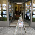 Un señor observa los anuncios de venta y alquiler de viviendas en una inmobiliaria