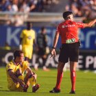 El delantero blanquivioleta Latasa se lamenta sentado sobre el césped de una acción en la que el árbitro señala falta.