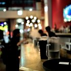 Clientes esperan su consumición en la barra de un bar.