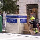 Un operario recoge cartones en un contenedor del centro de Valladolid.