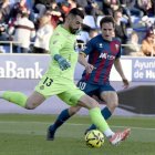 Guilherme se dispone a despejar ante el acoso de Kortajarena, atacante del Huesca.